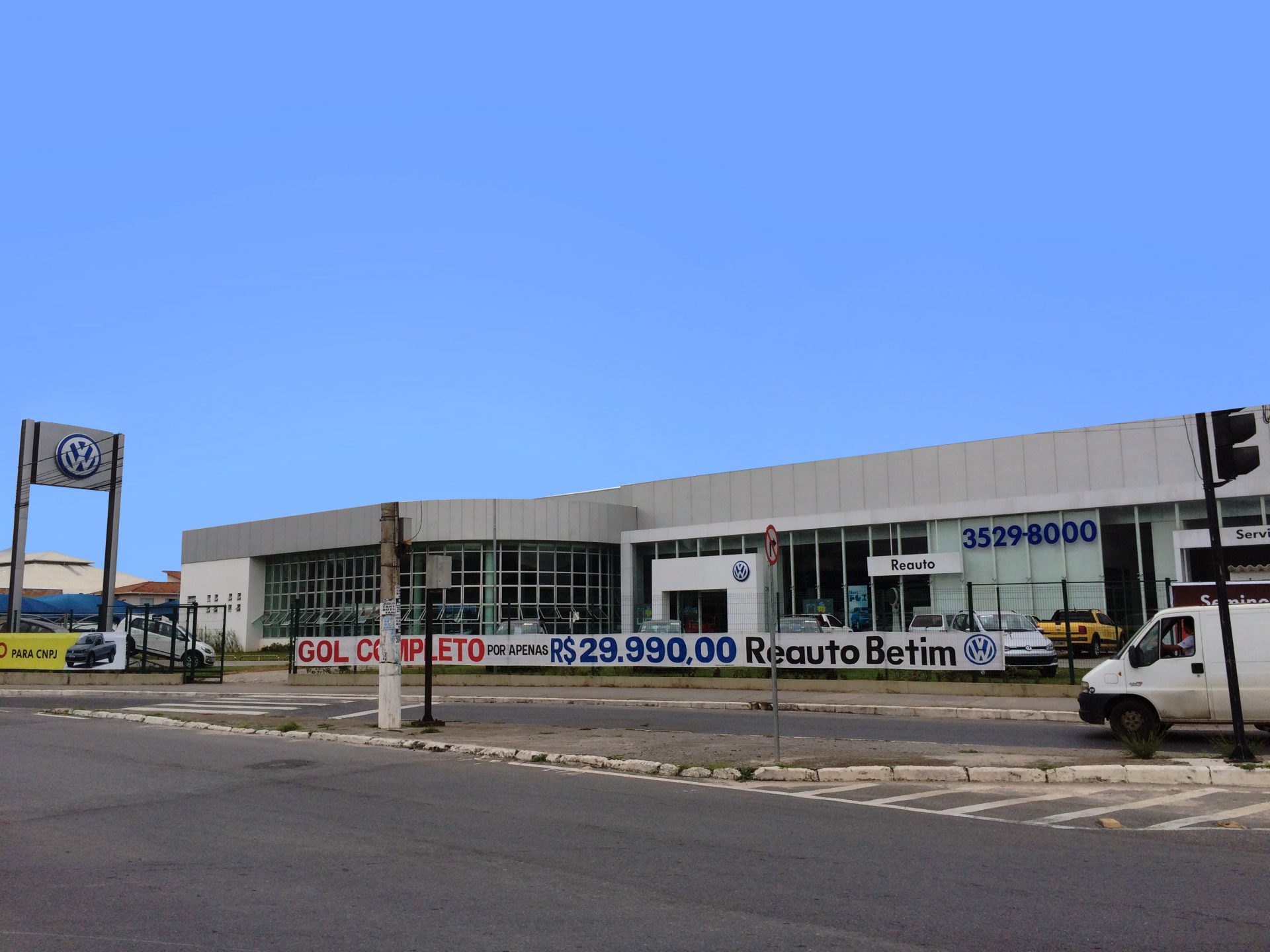 Showroom da concessionária Reauto Betim com fachada em vidro e painéis brancos